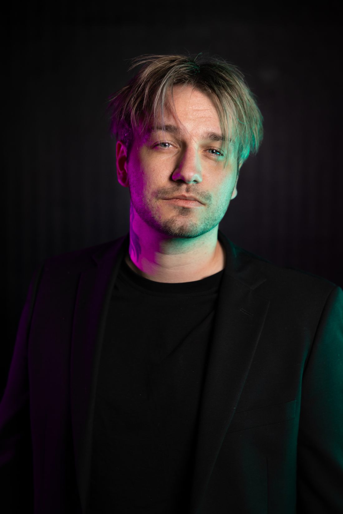 Portrait of Johan, founder of Vegillito Studio, lit in magenta and teal